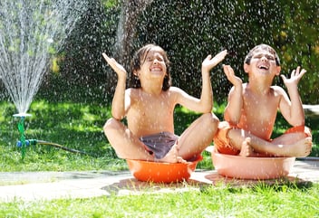 kids playing with a hose in the summer